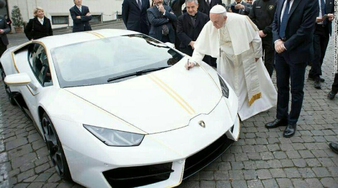 پاپ فرانسیس در حال امضای لامبورگینی سفید و زرد رنگی که روز چهارشنبه هدیه گرفت.